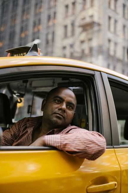 Chauffeur de taxi accoudé à la portière, joignable directement par téléphone