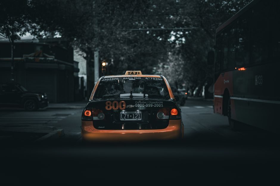 Taxi en approche sur une avenue en soirée pour un trajet privé